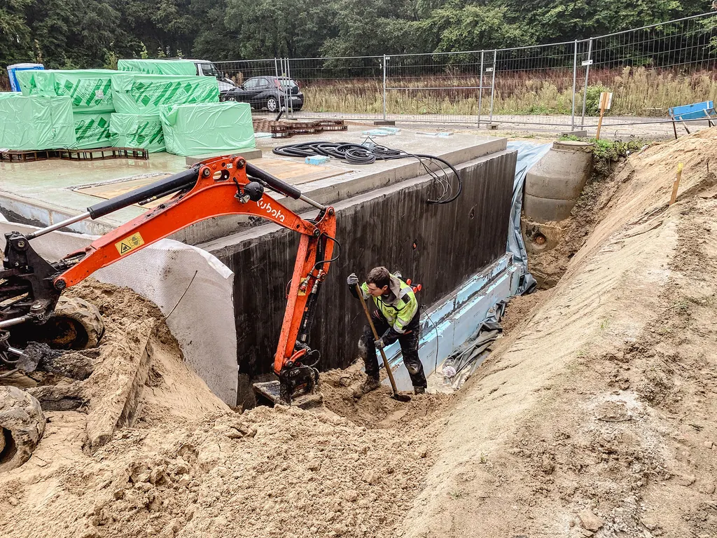 Bagger hebt eine Baugrube an einem Neubau aus